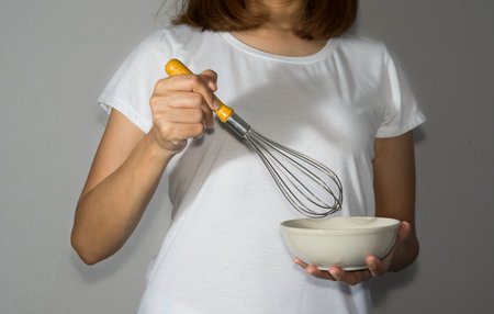 Woman holding bowl and whisk.の写真素材