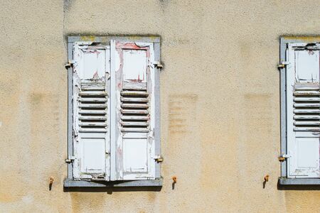 Window shutter, old and crapped, color flaked off.の写真素材