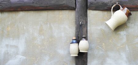 Three white jugs hanging on the wallの写真素材