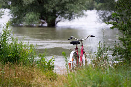 Red old Ladies bike stand by the lakeの写真素材