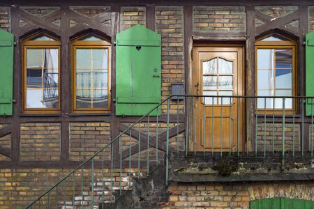 Brick wall house with green window shutterの写真素材
