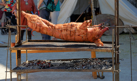 Medieval Festival: Roasted pig at the spit on an open fireの写真素材