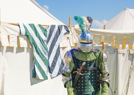 Empty knight's armour in front of white tents in the backgroundの写真素材