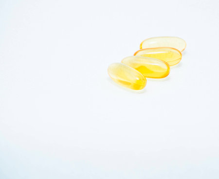 Golden fish oil gel capsules on white backgroundの写真素材
