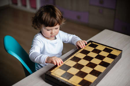 Little girl with a wooden chessboardの写真素材