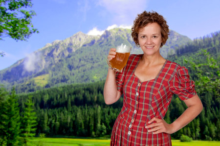 Mid age smiling woman holding a beer in her handsの写真素材