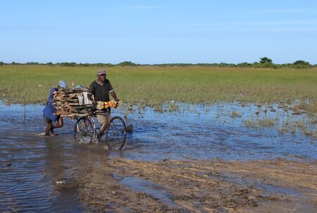 Rural living - villagers cross a flooded road in Mozambique, Africaのeditorial素材