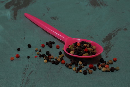 Peppercorns in a pink spoonの写真素材