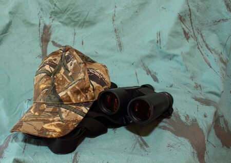 Cap and binoculars on green backgroundの写真素材
