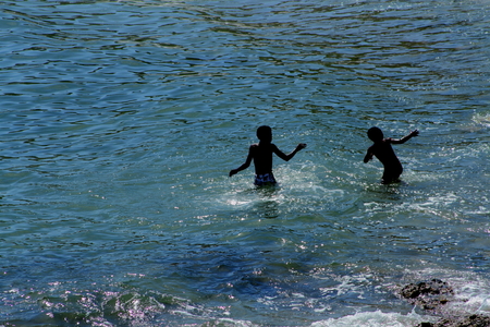 Children frollic in the seaの写真素材