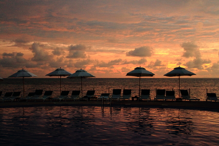 Umbrellas and deck chairs at sunsetの写真素材