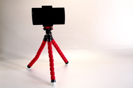 A smart phone on a pink tripod