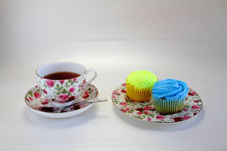 A cup of tea and two cupcakesの写真素材
