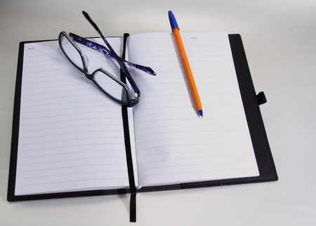 A notebook with glasses and a penの写真素材