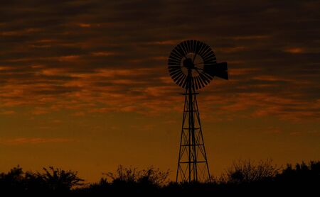 Windmill silhouetted at sunset Namaqualand Northern Cape South Africaの写真素材