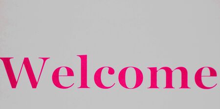 Welcome sign - pink lettering on a white backgroundの写真素材