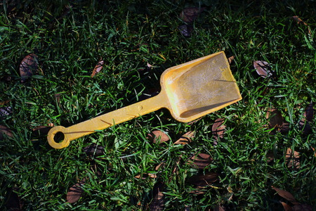 An abandoned and faded yellow child's toy spadeの写真素材