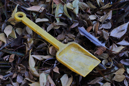 An abandoned and faded yellow child's toy spadeの写真素材