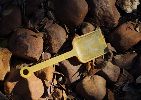 An abandoned and faded yellow child's toy spadeの写真素材