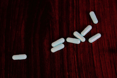 Blue capsules on a dark background in landscape format with copy spaceの写真素材