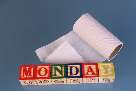 The term Monday next to a roll of toilet paper visually displayed on a white background using colorful wooden toy blocks in landscape format with copy spaceの写真素材