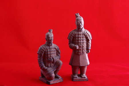 Two model terracotta warriors against a red background image in landscape format with copy spaceの写真素材