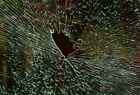 A shattered safety glass window displays interesting spider web patterns