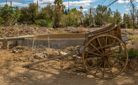 Weathered vintage wooden wagon exposed to the elements in a farmyardの写真素材