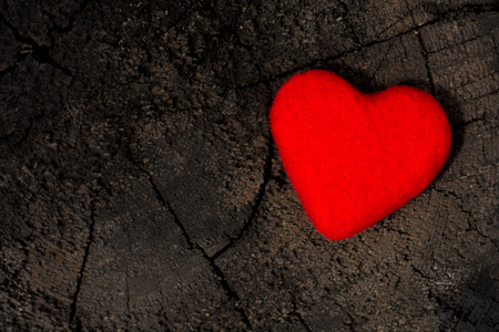 A red lonely loving handmade heart on an old wood. A symbol of love, loneliness and hope.の写真素材