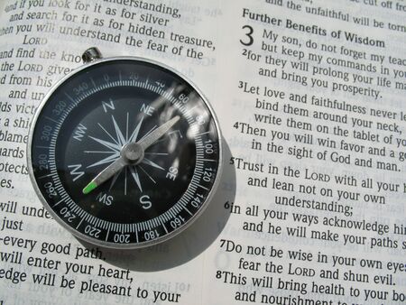 A compass and a bible on the verse of Proverbs 3:5-6 Trust in the LORD with all your heart and lean not on your own understanding, in all your ways acknowledge him, and he will make your paths straight.の写真素材