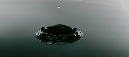 Falling drops of water. Splash effect after collision a falling water drops with Surfaceの写真素材