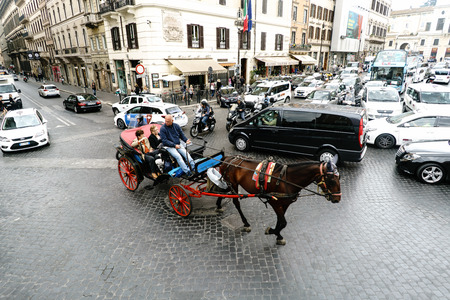 Rome, Lazio, Italy. July 20, 2017. Typical colle of horses with tourists strolling between the cars...
