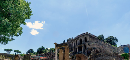 View of the various ruins of the Roman Forum with a very blue sky slightly cloudy without people in sightの写真素材