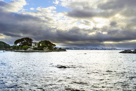 Castle on an island near the coast in the summer city called Santa Cruz (La Coruna) in a dramatic sunset and some sunbeamsのeditorial素材