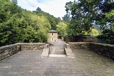 View of a restored stone building from the access road to the 10th century Monasterio de Caaveiro,...