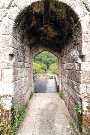 Stone arches access to the Monastery of Caaveiro dating from the tenth century and which hosted hermits of the area, in Galicia, Spain. A very green landscape without peopleの写真素材