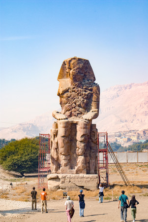 Luxor, Egypt. February 19, 2017: View of one of the memnon colossi dedicated to the pharaoh Amenhotep III and located at the osete and near the city and surrounded by scaffolding for restorationのeditorial素材