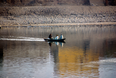 Nile River, near Aswan, Egypt. February 21, 2017: Two Muslim men and women dressed in djellaba...