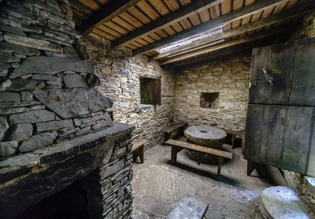 Interior of a kitchen in an ancient rural house in Galicia, Spain. You can see the fireplace and the dining table with its benchesの写真素材