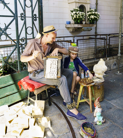 Porto, Portugal. August 12, 2017: Father and son musicians performing at the market entrance called Do Bolhao with birds on the shoulders and head and playing chessのeditorial素材