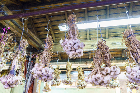 Garlic strings hanging from the ceiling at a market stall called Do Bolhao in the center of Porto (Portugal)の写真素材