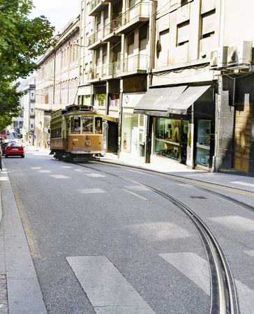Porto, Portugal. August 12, 2017: Typical tram going up a street in the center of Porto with a bend in the railsのeditorial素材