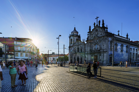 Porto, Portugal. August 12, 2017: Backlight of the Plaza de Gomes Teixeira with two baroque churches in the background and tourists strolling through itのeditorial素材