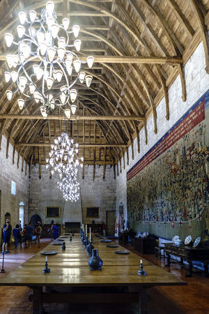 Guimaraes, Portugal. August 14, 2017: General view of the main hall of the palace of the Dukes of Braganza with wooden coffered ceiling, large lamps a large embroideredのeditorial素材