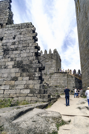 Guimaraes, Portugal. August 14, 2017: ruins of the interior of the 11th century royal castle built by Afonso Henriques with remains of very thick granite stone walls and tourists visiting itのeditorial素材
