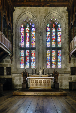 Guimaraes, Portugal. August 14, 2017: Altar of the chapel of the palace of the Dukes of Braganza flanked by two angels sculpted in wood and with large polychrome and leaded windows behindのeditorial素材