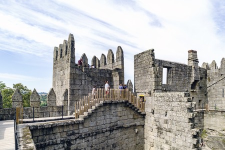 Guimaraes, Portugal. August 14, 2017: People walking through the walls of the castle of King Afonso Henriques built in the eleventh century and in good condition next to a watchtowerのeditorial素材