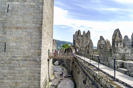 Guimaraes, Portugal. August 14, 2017: View of the bridge between the walls and the keep of the castle of the king of Portugal Afonso Henriques, built in the 11th century and very well preserved. With tourists passing through itのeditorial素材
