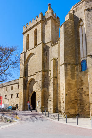 Laguardia, Alava, Spain. March 30, 2018: Medieval entrance door to the village located in the church-fortress of San Juan of mixed Romanesque-Gothic styles with a tower above and partial view of the apse of the churchのeditorial素材