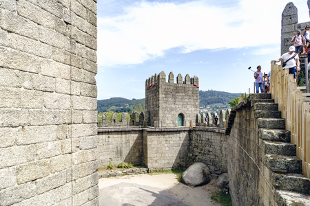 Guimaraes, Portugal. August 14, 2017: Walls of the castle of King Afonso Henriques built in the eleventh century and in good condition, with people walking over themのeditorial素材